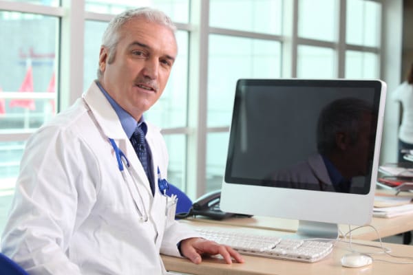 Male Mature Doctor Looking Over Shoulder Computer-Cropped Blue Clinical Diagnosis of Neurogenic TOS
