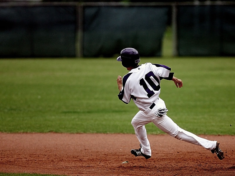 Baseball player rounding the bases at speed.