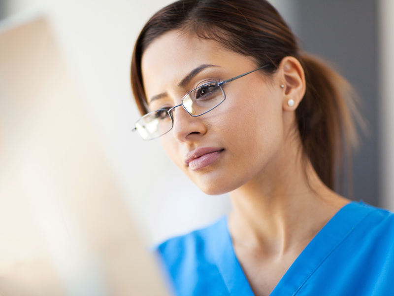 Female Young Exotic Doctor Blue Scrubs Reviewing X ray Cropped