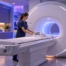 Radiology technologist preparing an MRI scanner in a blue and violet imaging suite
